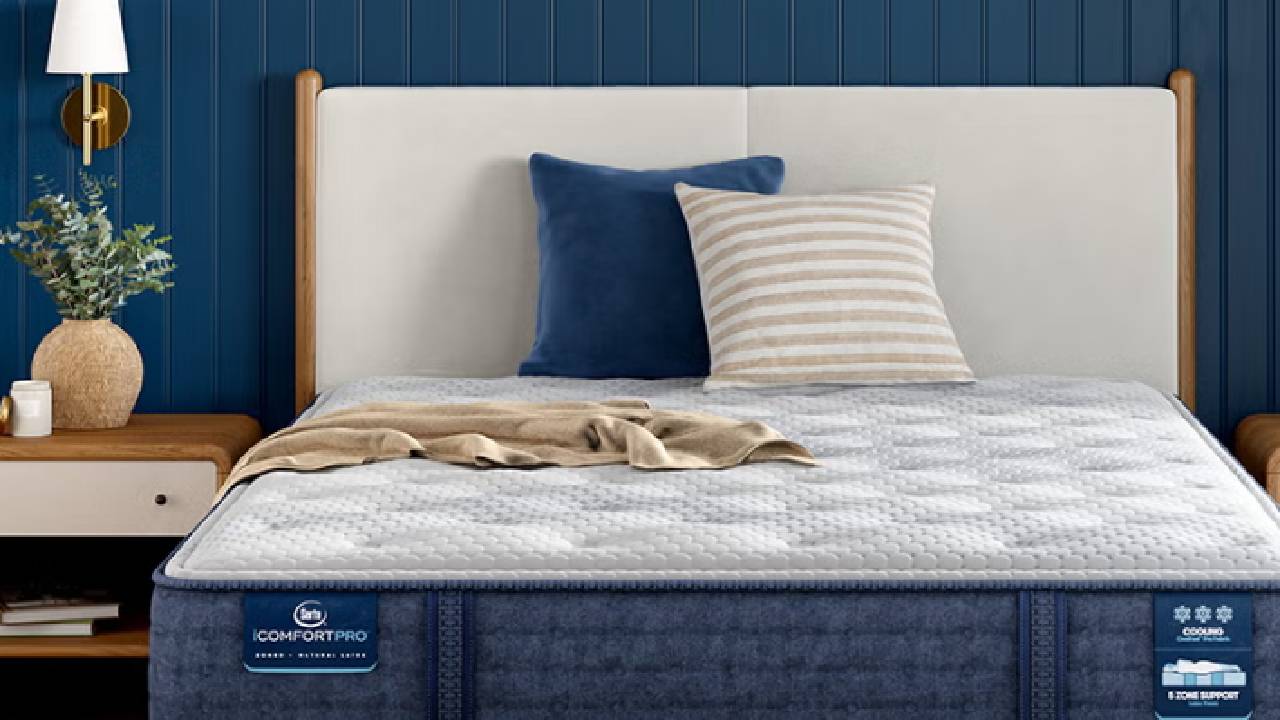 A Serta mattress in a navy blue, modern bedroom.