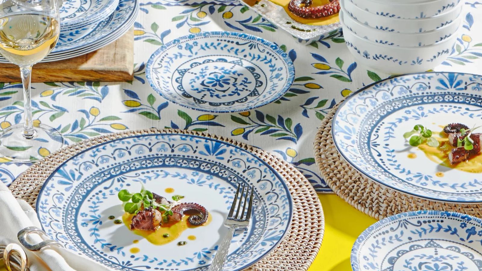 Blue and white painted dinnerware on bright yellow tablecloth