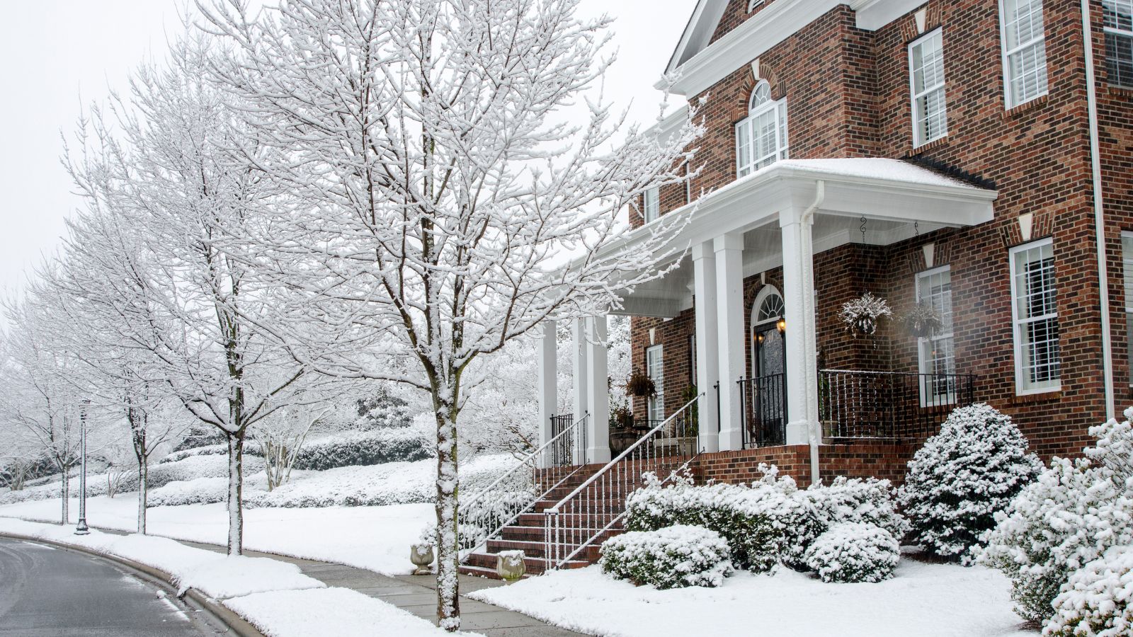 A traditional brick American home in snow. 