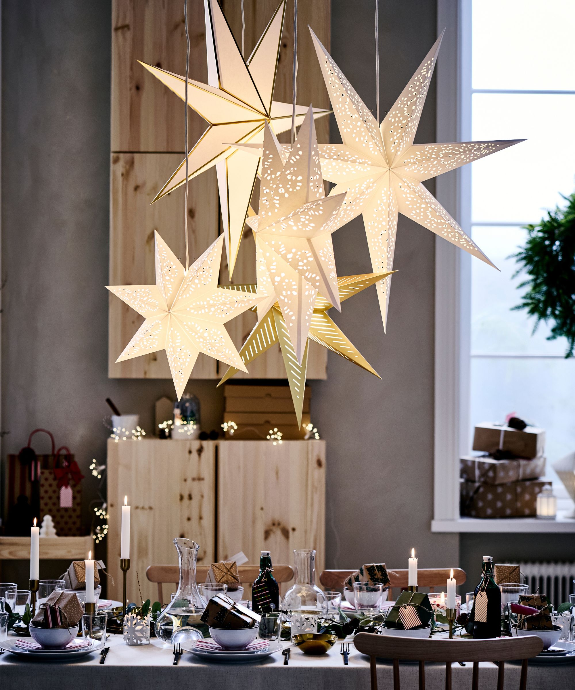 Ikea paper stars grouped together and hung over a dining table