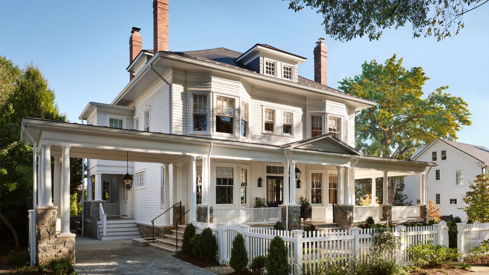 Queen anne home with white exterior, porch and columns and picket fence