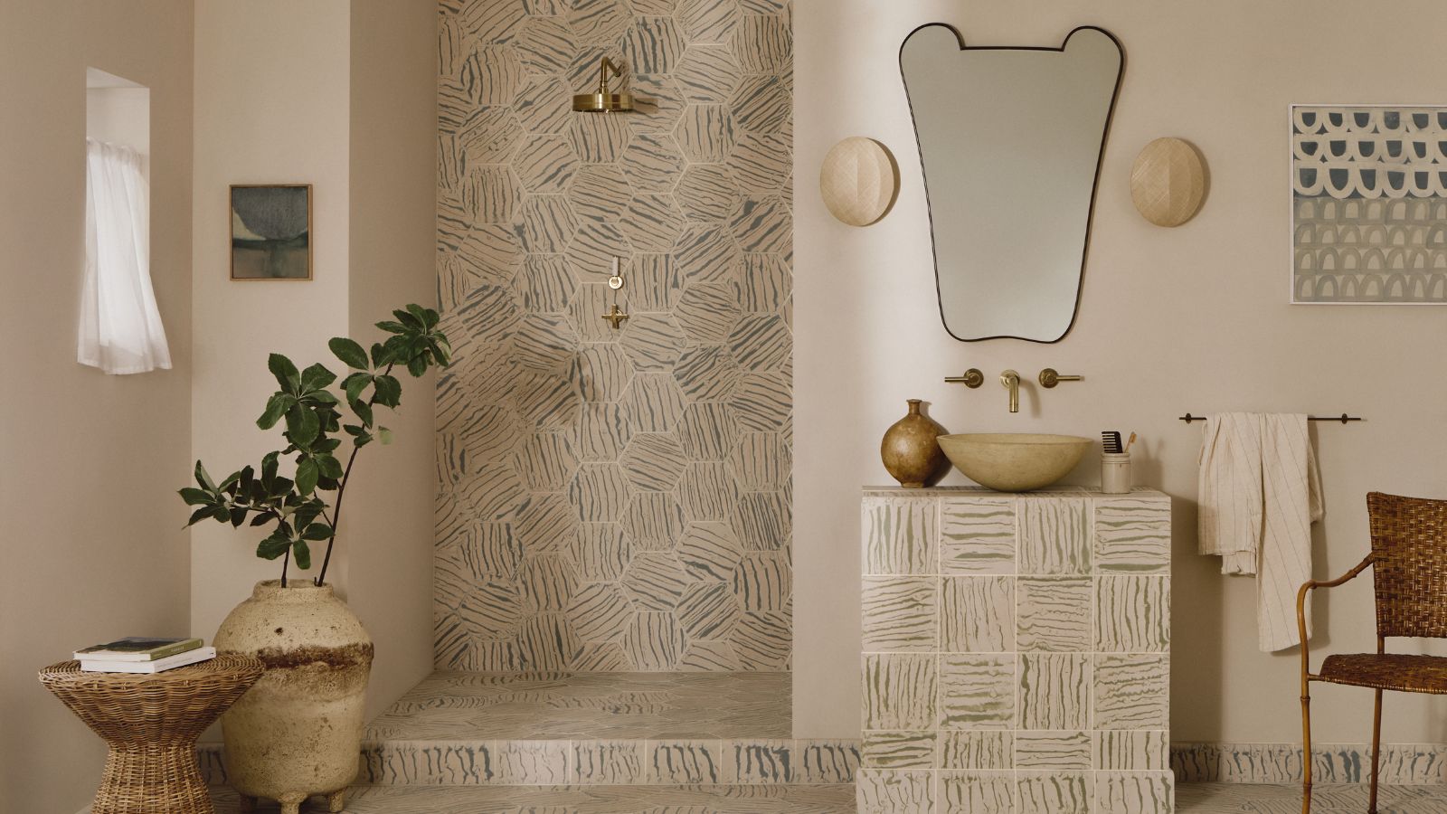 A neutral bathroom with patterned tiles in the shower nook, vanity, and floor