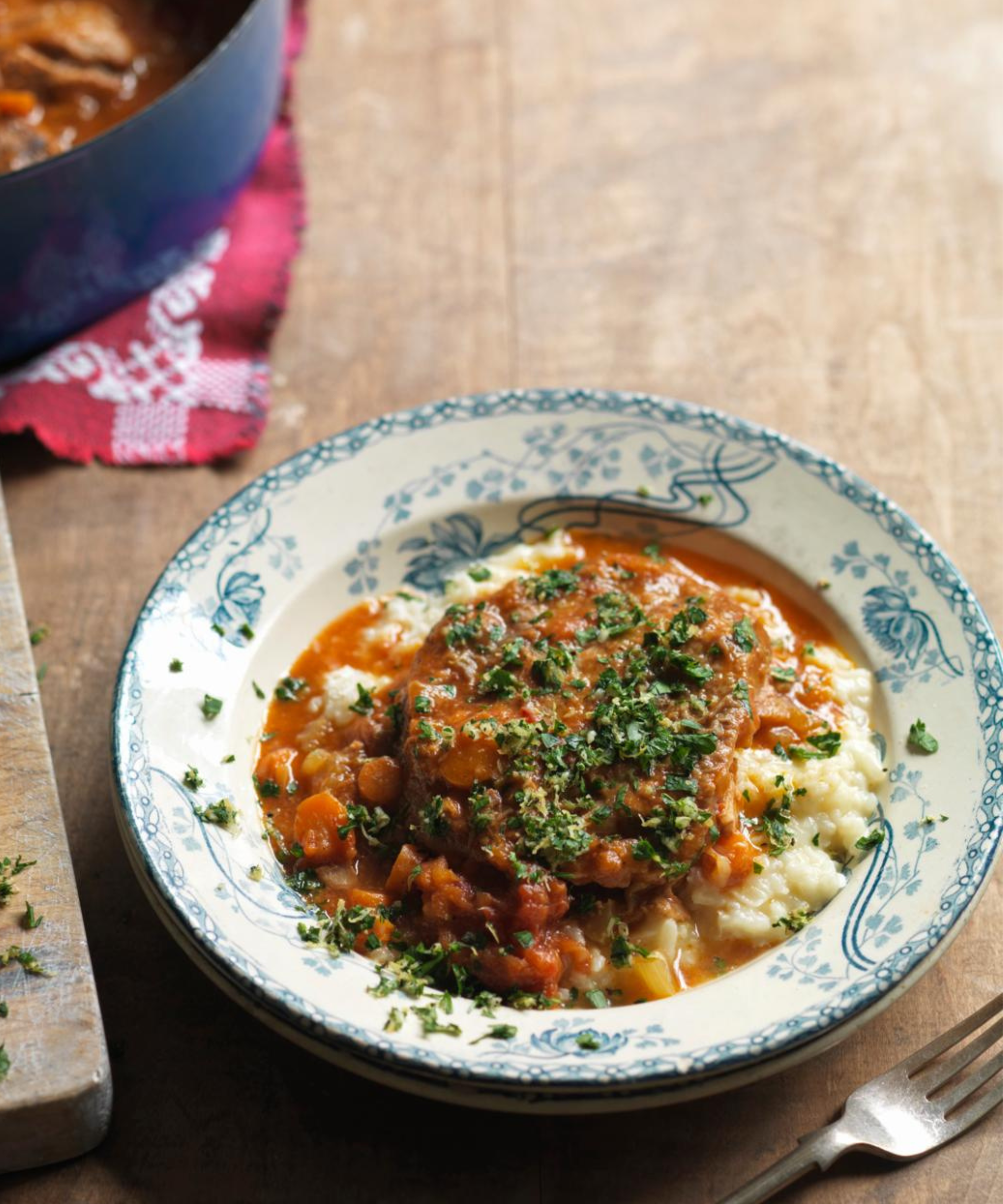A saucy Italian stew on top of mashed potato, served in an vintage-style bowl plate